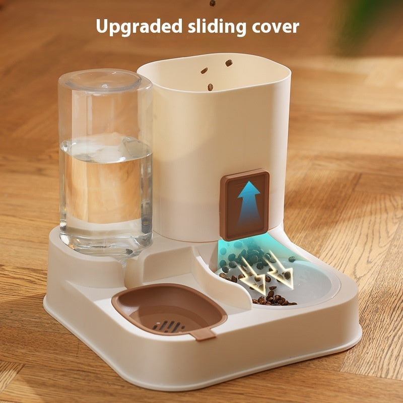 Pet Supplies Automatic Pet Feeder & Water Dispenser An automatic pet feeder with a stainless steel bowl and a clear water reservoir, in a color close to beige, with a cat eating from it with text upgraded sliding cover