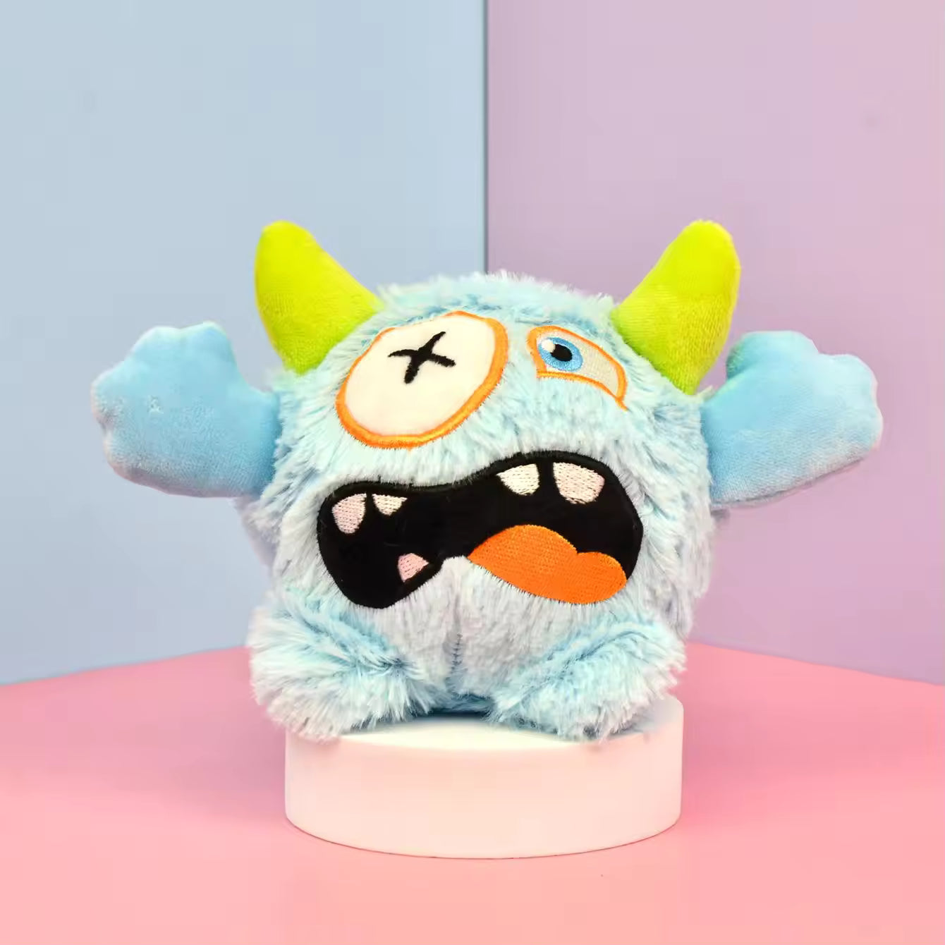 Pet Supplies Interactive Squeaky Plush Dog Toy Plush toy monster with a blue face and green horns on a pink and blue background